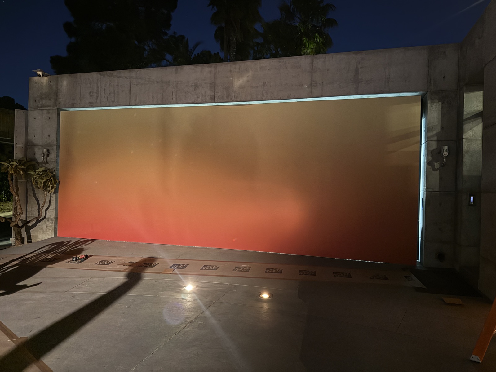 Large backlit gradient panel on outdoor terrace at night
