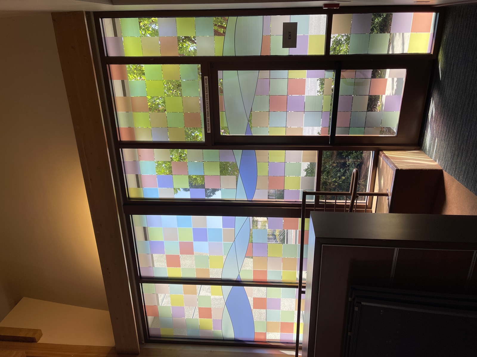 Colorful mosaic patterned window film on multi-panel glass wall