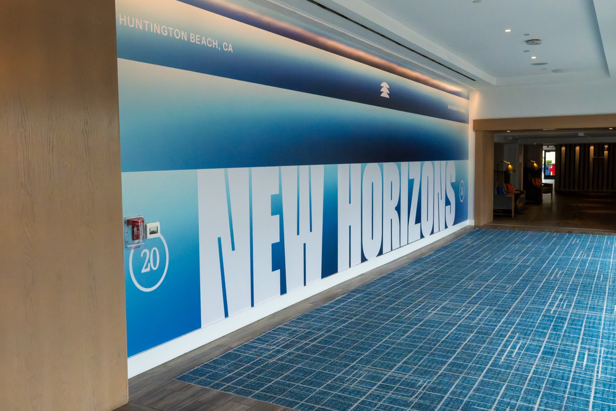 Large-scale NEW HORIZONS wall graphic in hotel hallway